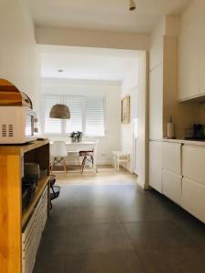 a kitchen with a table and a dining room at Apartamento espaçoso e confortável no centro do Montijo in Montijo