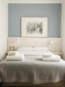 - un lit avec deux oreillers et un tableau au-dessus dans l'établissement Apartamento espaçoso e confortável no centro do Montijo, à Montijo