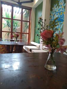 a vase filled with flowers sitting on a table at Casa 5 Bed & Breakfast in Palenque