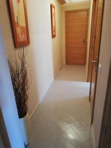a hallway with a door and a vase on the floor at Apartamento centro in Antequera