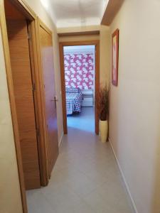 a hallway with a door and a bed in a room at Apartamento centro in Antequera