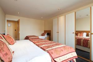 Habitación de hotel con 2 camas y mantas rojas y blancas en Queens Mansions: Duchess Suite, en Blackpool