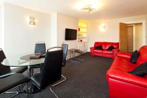 a living room with a red couch and a table at Queens Mansions: Duchess Suite in Blackpool