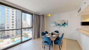 a dining room with a table and chairs and a large window at Lux BnB Dubai Creek Residences Harbour Views in Dubai