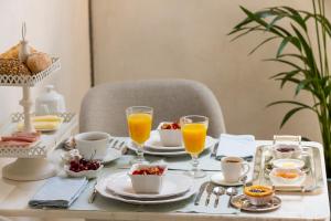 a breakfast table with a tray of food and orange juice at Romantic - Casa Rua Bela in Porto