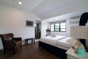 a bedroom with a bed and a chair and a window at Jomstay Mayhaven Villa (Ipoh) in Ipoh
