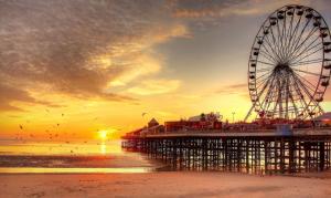 a ferris wheel on the beach with a pier at Fabrik: Winter Gardens Service Apartments 2 in Blackpool