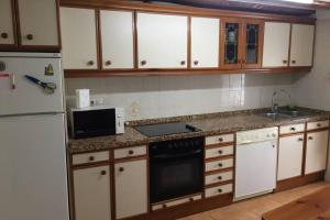 una cocina con electrodomésticos blancos y armarios de madera en Buenavista Olite, en Olite