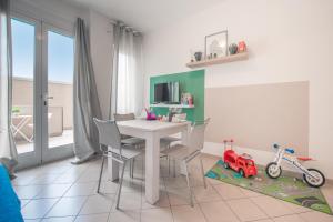 a dining room with a table and a toy car on a rug at Babyaccommodation Family Comfort in Pietra Ligure