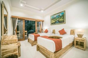 a bedroom with two beds and a window at Adenia House Ubud in Ubud