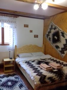 a bedroom with a bed with a blanket on it at Guest House Grunyk in Yaremche