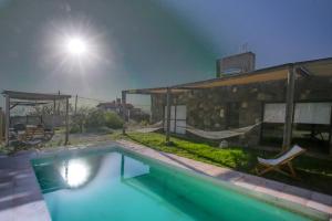 a swimming pool in front of a house at night at Pedemonte in Las Heras
