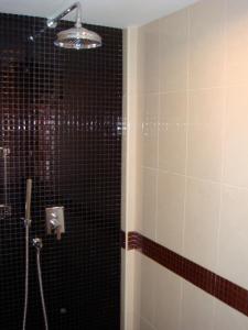 a bathroom with a shower with black tiled walls at Sunset Apartment Phuket in Patong Beach