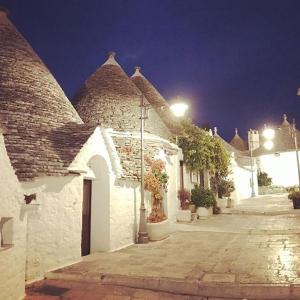 un gruppo di edifici bianchi con una strada di notte di Trullo Nobilis ad Alberobello Altre 37 foto