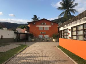 una casa con una palma di fronte a una strada di Village com 4 APTOS PÉ NA AREIA E PISCINA a São Sebastião