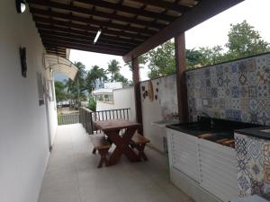 una cucina con un tavolo e una panca su un balcone di Village com 4 APTOS PÉ NA AREIA E PISCINA a São Sebastião