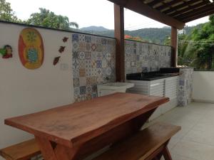 una cucina con un tavolo di legno e una stufa di Village com 4 APTOS PÉ NA AREIA E PISCINA a São Sebastião