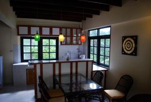 a kitchen with a glass table and some chairs at Sunset Apartment Phuket in Patong Beach