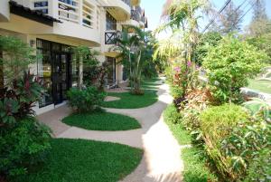 una pasarela frente a un edificio con plantas en Sunset Apartment Phuket, en Patong Beach