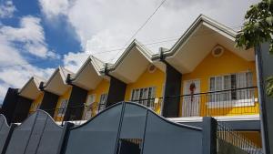 a yellow house with a slide in front of it at Diodeth's Apartments in Butuan