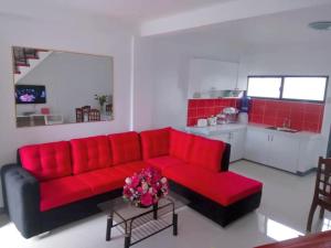 a living room with a red couch and a kitchen at Diodeth's Apartments in Butuan