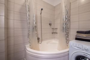 een badkamer met een douche en een wasmachine bij Studio Residence Militari in Boekarest