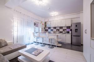 a kitchen and living room with a couch and a table at Studio Residence Militari in Bucharest