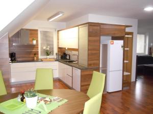 a kitchen and dining room with a table and yellow chairs at Apartment WELLNESS Vlčková in Vlčková