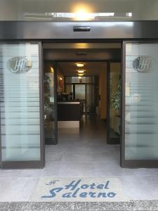 un vestíbulo de hotel con puertas de cristal y una señal en él en Albergo Salerno, en Milán