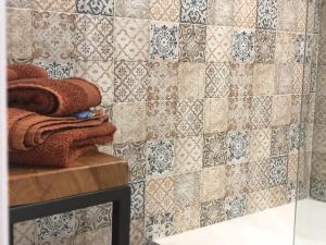 a bathroom with a tiled wall with a towel at B&B Terra Marique in Siracusa