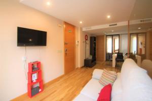 Una sala de estar con un sofá blanco y un televisor de pantalla plana. en Modern CasaTuris Apartment with Castle Views A131, en Alicante