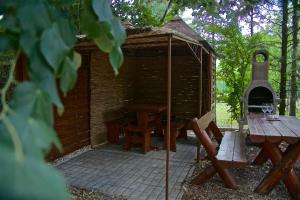 a small brick building with a grill and a picnic table at Aranypart Vendégház - Tiszakécske in Tiszakécske