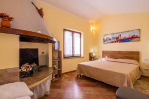 1 dormitorio con 1 cama y chimenea en Terrazza Santa Chiara, en Asís