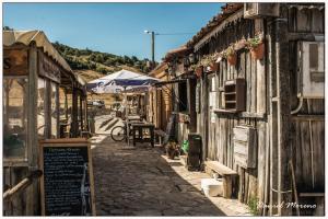 an alley in an old town with an umbrella at Casa da Palmeira in Outeiro da Cortiçada