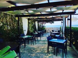 トッレ・サン・ジョヴァンニ・ウジェントにあるLa Giara Resortのパーゴラの下にテーブルと椅子があるレストラン