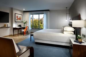 
a hotel room with a bed, chair and a window at Hyatt Regency Hesperia Madrid in Madrid
