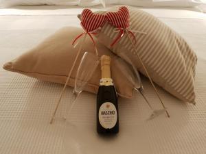 a bottle of wine on a bed with a pillow at Il Mare Di Roma Luxury in Lido di Ostia