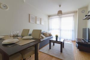 a living room with a dining table and a tv at Krynica Apartamenty Przytulny apartament w Centrum 54 in Krynica Zdrój