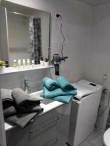 a bathroom with a sink and a mirror and towels at STUDIO VILLA NUI in Cuers