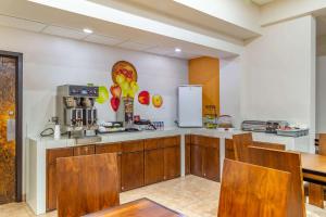 a kitchen with wooden cabinets and a counter top at Comfort Inn Chihuahua in Chihuahua