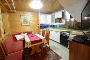 a small kitchen with a table and a red couch at Apartment Dijak in Bohinj