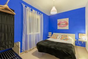 セビリアにあるSevillaHome Teodosio 27の青いベッドルーム(赤い唇の壁にベッド付)