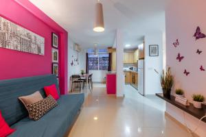 salon z kanapą i różową ścianą w obiekcie SevillaHome Teodosio 27 w Sewilli