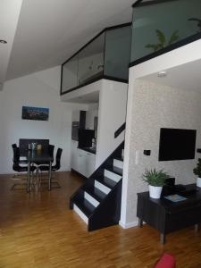 a living room with a staircase and a dining room at Backbord Und Steuerbord in Stralsund