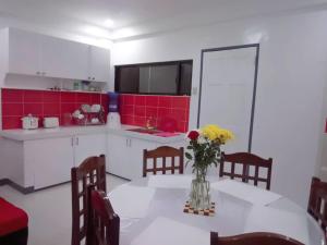 a kitchen with a table with a vase of flowers on it at Diodeth's Apartments in Butuan