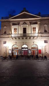 a large white building with benches in front of it at Hotel Du Parc in Atri