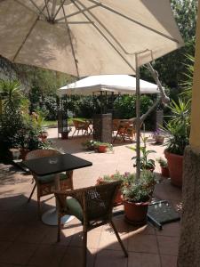 un patio con mesa, sillas y sombrilla en Albergo Salerno, en Milán