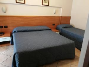 a bedroom with two beds with blue covers at Albergo Salerno in Milan