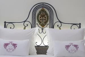 a bed with white pillows and an iron headboard at Quinta Rainha Santa Mafalda in Pinhão +36 photos