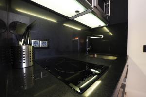una cucina nera con piano cottura e lavandino di El Semáforo - Lujo, Confort y Vistas Espectaculares a Sierra Nevada Altre 37 foto